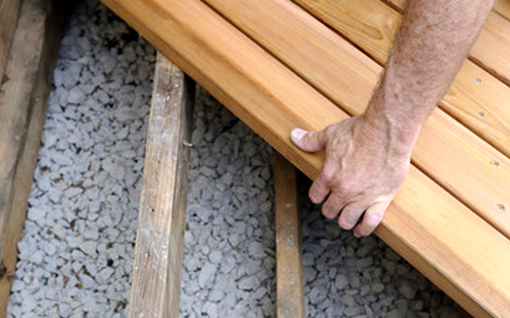 Landscaper fitting timber decking boards
